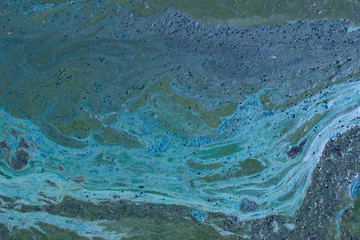 Cropped shot of dirty water, top view. Ecology, environmental pollution, nature concept. Abstract colorful background texture.