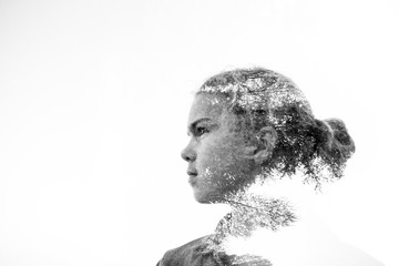 Double exposure of a girls's profile silhouette with tree branches