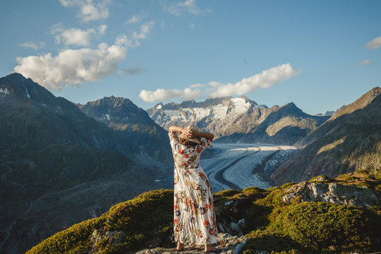 A woman in a flowered dress and straw hat at the Aletsch Glacier