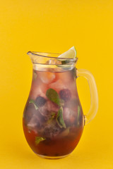 Jug of summer seasonal lemonade with blackberry, like, berries and mint isolated on bright flat background