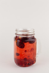 Red herbal tea with cranberry, blueberry, strawberry, lemon and honey isolated on white background as a perfect autumn drink