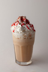 Ice cold coffee ? caramel frappe with whipped cream, sprinkles and strawberry topping isolated on...