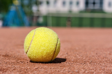 close-up yellow tennis ball on clay court in sport academy for practice of tennis