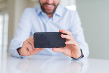 Close up of man hands using smartphone and smiling