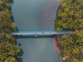 Aerial view of Sadolxem bridge over Talpon river with a boat in Canacona , South Goa, India.
