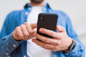 Close up of man hands using smartphone and smiling