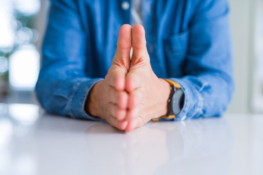 Close up of man hands with palms together over white table