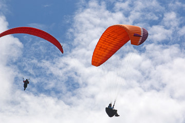 paragliders flying in a blue sky