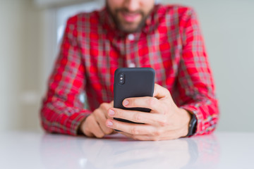 Close up of man hands using smartphone and smiling