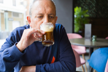Handsome middle age senior man drinking coffee at restaurante, smiling happy enjoying and relaxing retirement