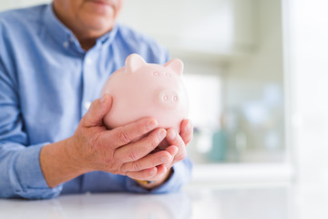 Man holding piggy bank carefully, saving money for retirement