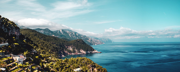 The wild north mountain coastline with clouds hanging in the tops and ocean panorama views. Estellencs, Banyalbufar, Serra de Tramuntana, Mallorca, Spain , Balearic Islands