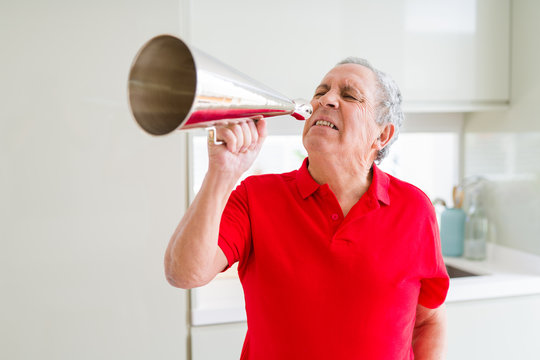 Senior man shouthing excited through vintage metal megaphone