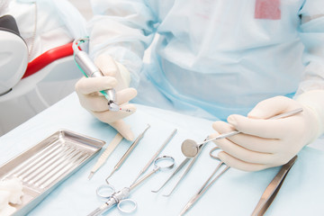 the dentist is holding the tools for implantation