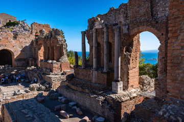Ruins of the Greek Theater in Taormina with groups of visitors in the afternoon