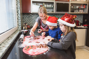 Happy family mother and children son and daughter bake pasta for Christmas