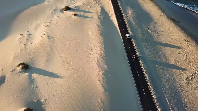 Long black asphalt road in the middle of the desert with nature and outdoors around - concept of travel and adventure in alternative beautiful senic place - aerial view