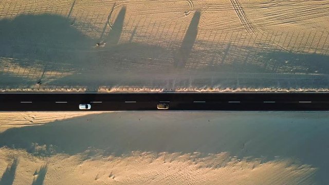 Long black asphalt road in the middle of the desert with nature and outdoors around - concept of travel and adventure in alternative beautiful senic place - aerial view