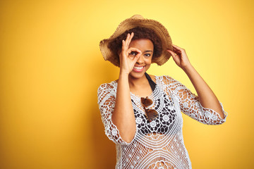 Young african american woman with afro hair wearing summer hat over white isolated background doing...