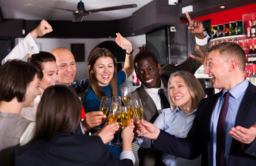 Colleagues clinking glasses of champagne on corporate party