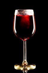 A glass of red alcohol on a black background