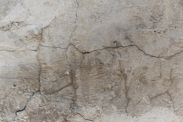 cracked concrete wall covered with gray plaster surface as background