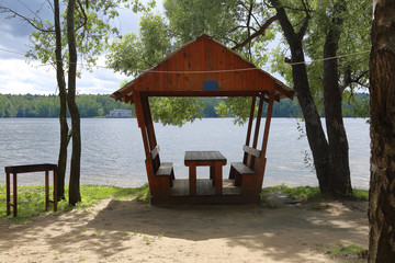 Part of a cozy beach cafe without visitors on the banks of the summer river