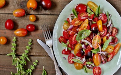 Fototapeta na wymiar cherry tomatoes salad of different colors and basil. bright summer salad. 