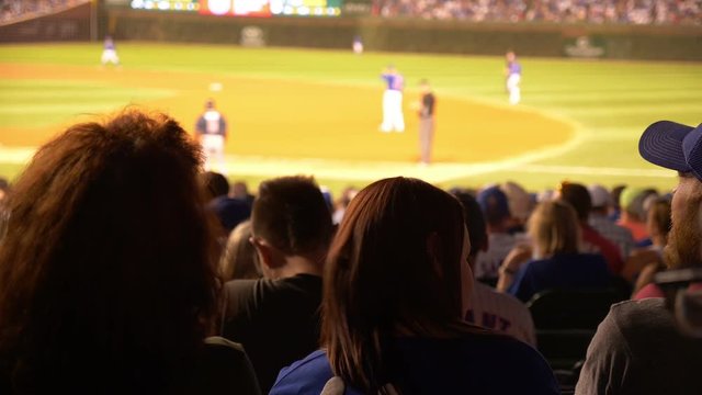People enjoying a night baseball game