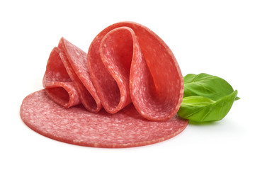 Salami sausage slices with basil leaves, close-up, isolated on white background