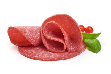 Thin salami sausage slices with basil leaves, close-up, isolated on white background