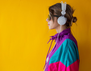 Young woman in 90s style clothes with headphones