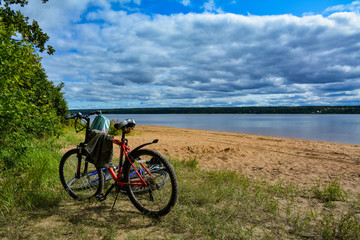Two bicycles on the shore of a large lake