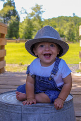 little boy in overalls and a hat