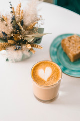 The cup of coffee with sweet cake in the coffee shop