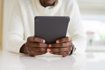 Close up of african business man using touchpad tablet, working sitting on a desk