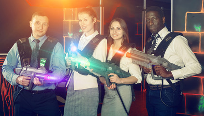 Fototapeta na wymiar Group of nice co-workers holding laser guns
