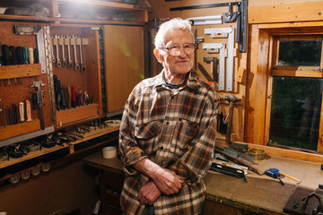 Portrait of amateur senior carpenter, taking pride in his workshop