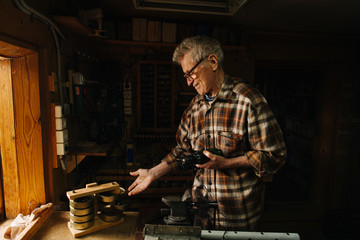 Amateur senior carpenter at his workshop, showing around