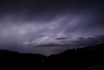 a dangerous storm in a summer night full of lighting bolts with view above the austrian city of leoben to the east