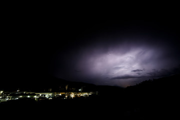 a dangerous storm in a summer night full of lighting bolts with view above the austrian city of leoben to the east