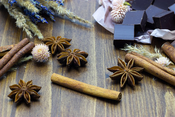 natural chocolate with lavender flowers cinnamon and star anise on a wooden background