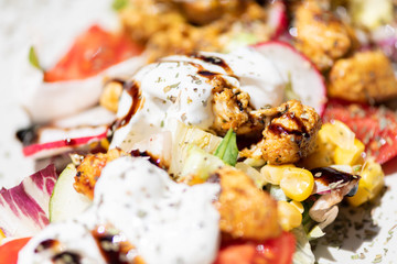 Close up of chicken salad with tomatoes, sweet corn, cucumber, cream and lettuce. Home made food. Concept for a tasty and healthy meal.