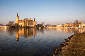 Fototapeta na wymiar Dawn at Schwerin Palace (Schweriner Schloss), reflected in the water of Schweriner See lake. World Heritage Site in Mecklenburg-Vorpommern, Germany