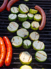 grilled sausages. cheese sausages fry on the grill with zucchini