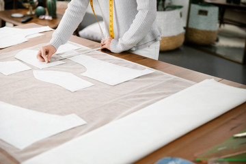 Close up of designer measuring pattern on fabric