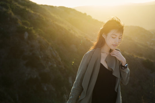 Young woman stand with eyes closed in hazy sunlight