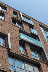 Obraz premium Vertical bottom shoot of brick and open glazing facade office building