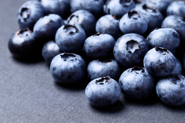 A lot of blueberries closeup on a black background. Top view