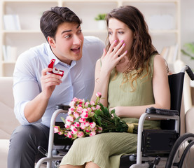 Man making marriage proposal to disabled woman on wheelchair